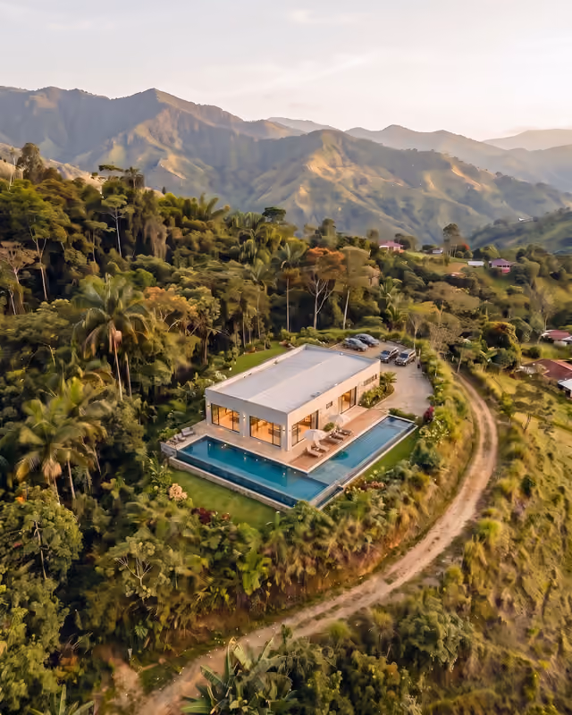 Casa terminada con piscina sobre un lote en la montaña.