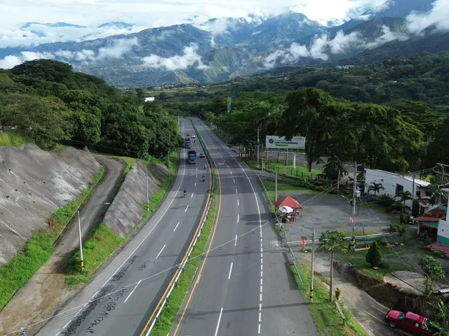 La vía de llegada entre montañas verdes.
